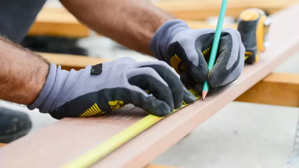 Carpenter measuring stud work on building