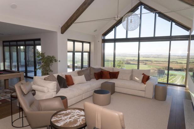 Living area of bespoke luxurious home with panoramic views of Saunton and a large television on wall