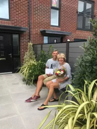 Happy couple sat in garden of new home in Taw Wharf Barnstaple 