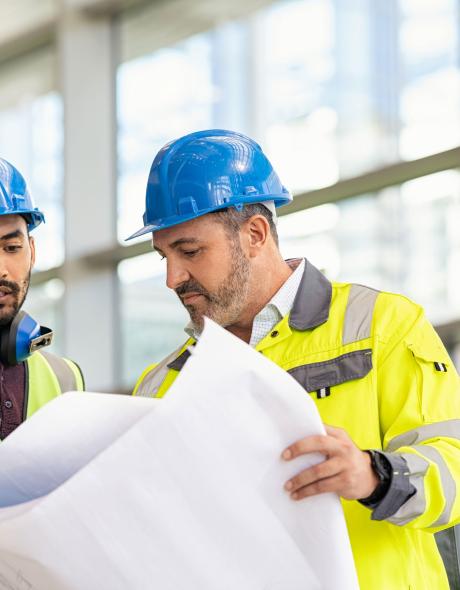 Two Building contractors discussing plans on Devon project