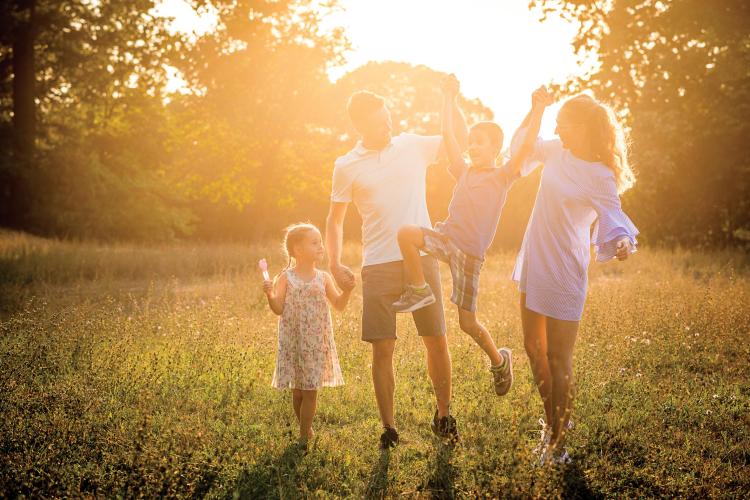 family of 4 walking in a field in North Devon