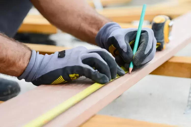 Carpenter measuring stud work on building