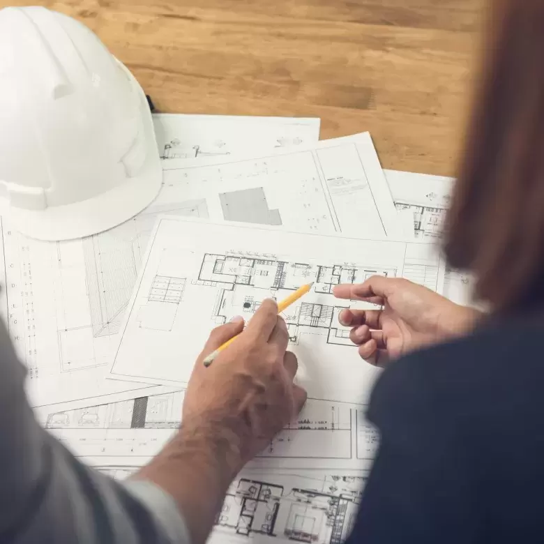 Architect and surveyor examining drawing plans